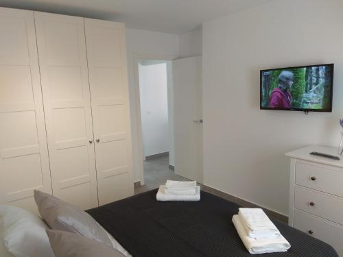 um quarto com armários brancos e uma televisão na parede em City Comfort em Estepona