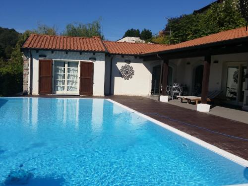 a swimming pool in front of a house at Villa Giotto in Fortunago