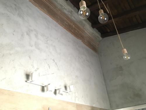 ローマにあるMaru Apartmentの洗面台3つ、壁に照明が付いたバスルーム