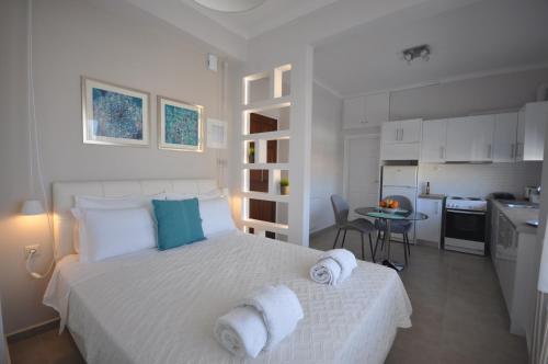 Un dormitorio blanco con una cama con toallas. en Apartments Chania, en La Canea
