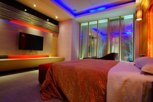 a bedroom with a bed and a flat screen tv at Water City Motel in Daya