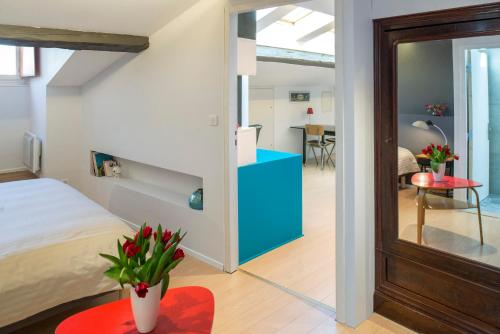 Un dormitorio con una cama y una mesa roja con flores en Appartement 9 Place d'Alliance, en Nancy