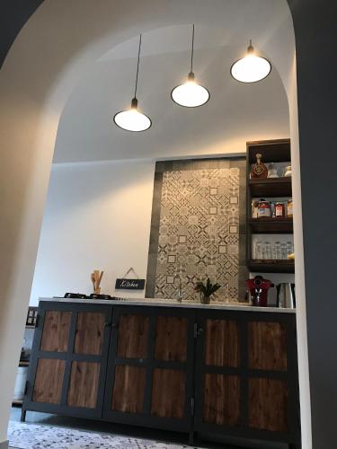a kitchen with two pendant lights and wooden doors at Il vecchio Fauno in Pompei