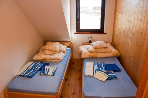 2 łóżka piętrowe w niewielkim pokoju z oknem w obiekcie Apartamenty pod dębem w Łukęcinie