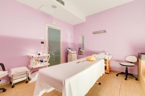 a hospital room with purple walls and a table at Villa Maria Hotel & SPA in Francavilla al Mare