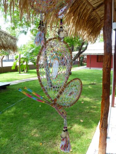 a bird cage hanging from a straw roof at Hostel Pousada do Tapajós in Alter do Chao