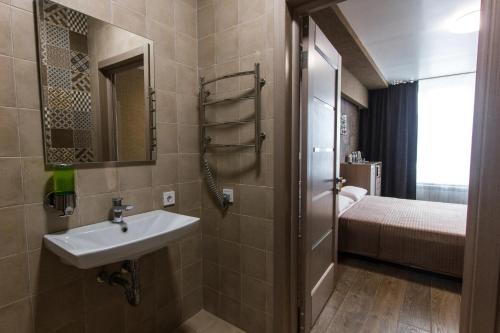 La salle de bains est pourvue d'un lavabo et d'un lit. dans l'établissement Solo Apartment Virmenska, à Kiev