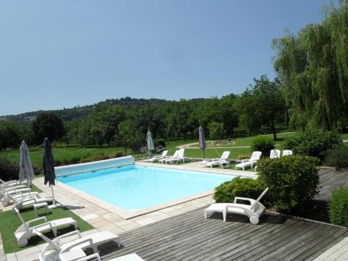 a swimming pool with lounge chairs and umbrellas at Domaine des Escouanes in Prudhomat