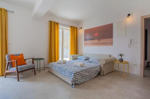 a bedroom with a bed and a couch and a chair at Apartment Garden breeze in Cres