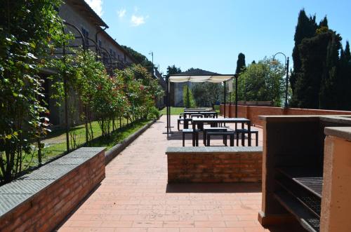 a patio with tables and benches next to a building at Agriturismo Le Case di San Vivaldo in Montaione