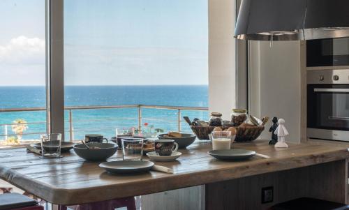 una cucina con tavolo e vista sull'oceano di View Point Apartment a Chania