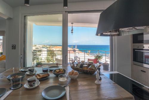 una cucina con tavolo e vista sull'oceano di View Point Apartment a Chania