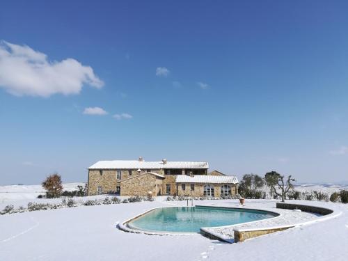 a house with a swimming pool in the snow at Casanova di Neri Relais in Montalcino