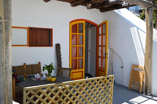 a porch of a house with a table and a door at Le Case del Capitano in Stromboli