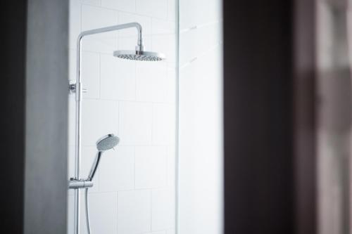 a shower with a shower head in a bathroom at Janevalla Bandung in Bandung