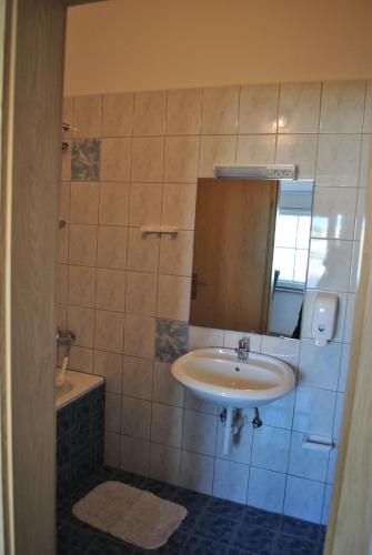 a bathroom with a sink and a mirror and a tub at Promenade in Medulin