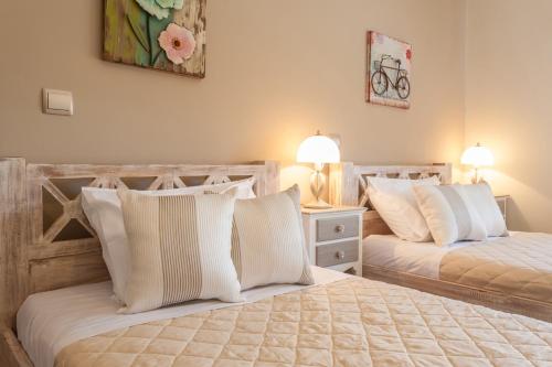 a bedroom with two beds with white pillows at Evgatis Beach Luxury Apts in Th&aacute;nos