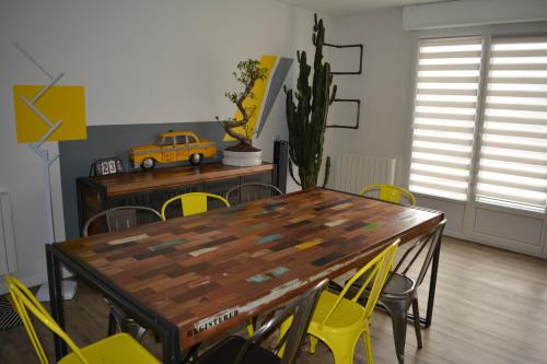 une salle à manger avec une table en bois et des chaises jaunes dans l'établissement Rullyoloft, à Rully