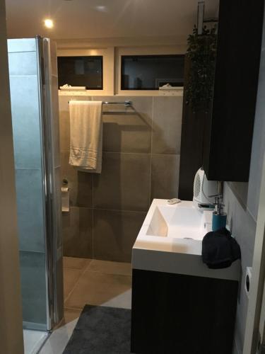 a bathroom with a white sink and a shower at Chill & Party in Breda