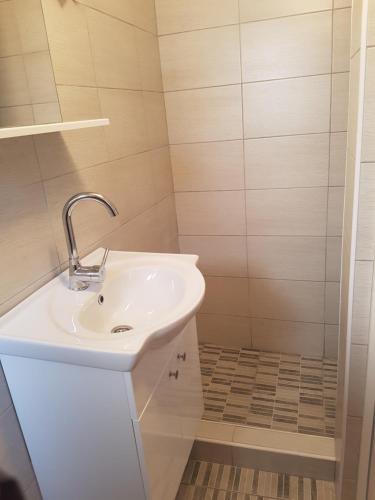 a bathroom with a white sink and a shower at Apartment Barbara in Kulen Vakuf