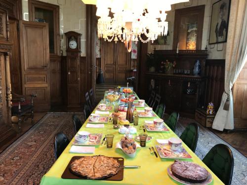 einen langen Tisch mit Essen auf einem Zimmer in der Unterkunft Chateau Marieville in Bonneuil-Matours