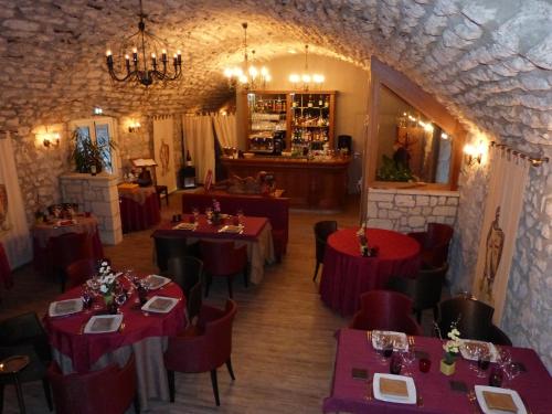 une salle à manger avec des tables et des chaises rouges dans l'établissement Logis Hôtel Le Relais Louis XI, à Meung-sur-Loire