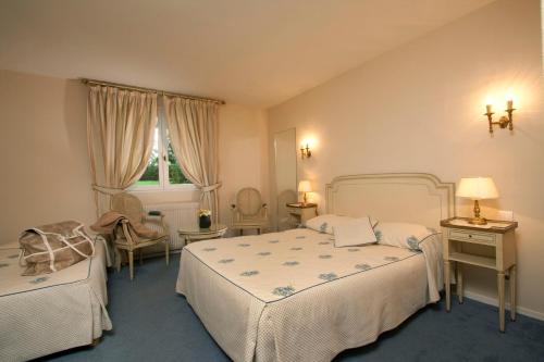 熱夫雷尚貝爾坦的住宿－藝術及風土條件之家酒店，一间卧室设有两张床、一把椅子和一个窗户。