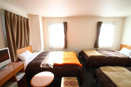 เตียงในห้องที่ โรงแรมซากุระ ฮาตากายะ