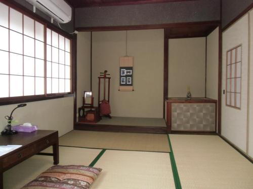 Habitación con mesa y ventanas. en Kanazawa Share House GAOoo, en Kanazawa