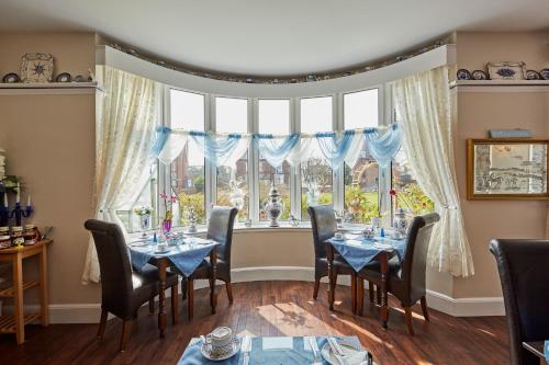 a dining room with tables and chairs and a large window at Barons Court in Great Yarmouth