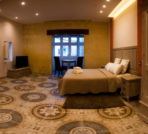 a hotel room with a bed and a table at Casa Azzopardi Suites in Rabat
