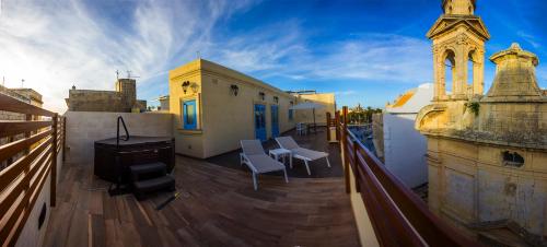 a balcony with chairs and a stove on a building at Casa Azzopardi Suites in Rabat