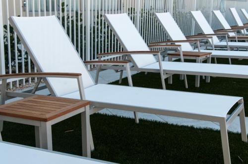 a row of white benches sitting on the grass at Ramada by Wyndham Venice Hotel Venezia in Venice
