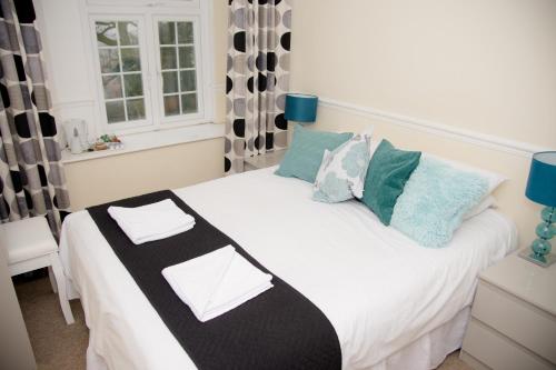 a bedroom with a white bed with pillows and a window at Brewers Lodge in Blackwood
