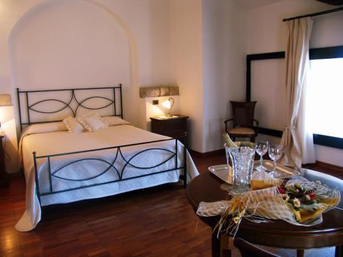 
a hotel room with a bed, table and chairs at Hotel Ristorante Le Clarisse in Amantea
