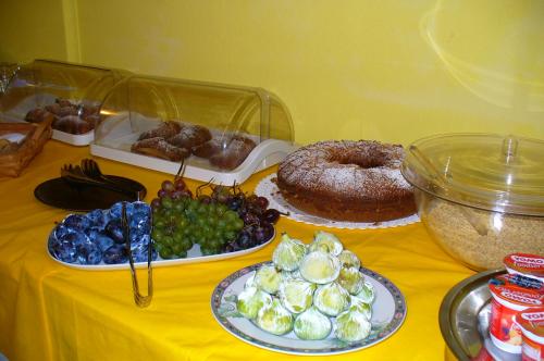 a table with plates of food on a yellow table at Hotel La Marticana in Ischia