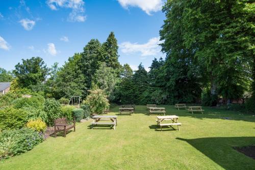 a group of picnic tables and benches in a park at Tankerville Arms Hotel in Wooler