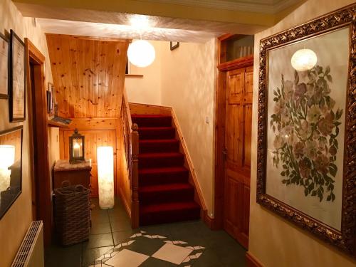 a hallway with a staircase in a house at Carraig-Mor House Bed & Breakfast in Toormore