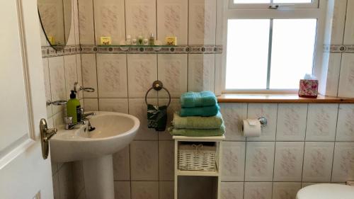 a small bathroom with a sink and a window at Carraig-Mor House Bed & Breakfast in Toormore