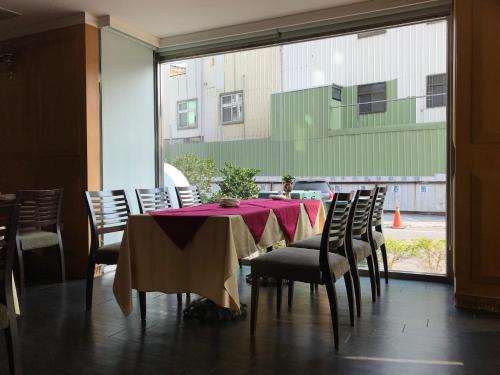 ein Esszimmer mit einem Tisch, Stühlen und einem Fenster in der Unterkunft Shiah Yih Hotel in Huwei