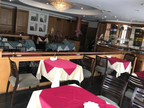 a restaurant with tables and chairs and a bar at Shiah Yih Hotel in Huwei