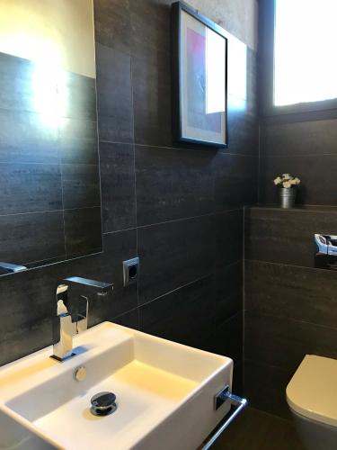 a bathroom with a sink and a mirror and a toilet at Niu in Saldet
