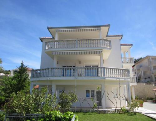 un grande edificio bianco con balcone di Apartmani Jureta a Okrug Gornji