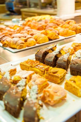 a buffet of food with pastries and other pastries at Hotel Montecarlo in Bibione