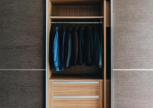 a walk in closet with blue clothes in it at JW Marriott Hotel & Suites Saigon, The Apartments in Ho Chi Minh City