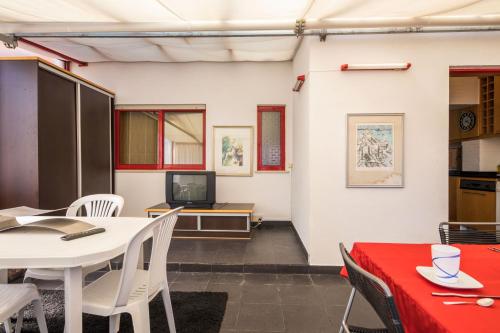 a room with a table and chairs and a television at Welcome Barra Apartment in Gafanha da Nazaré