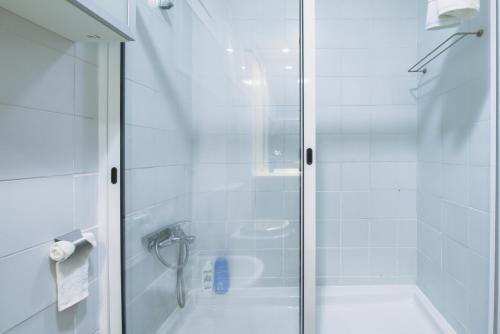 a shower with a glass door next to a tub at Welcome Barra Apartment in Gafanha da Nazaré