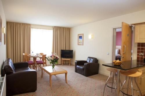 a hotel room with a living and dining room at Lahinch Coast Hotel and Suites in Lahinch