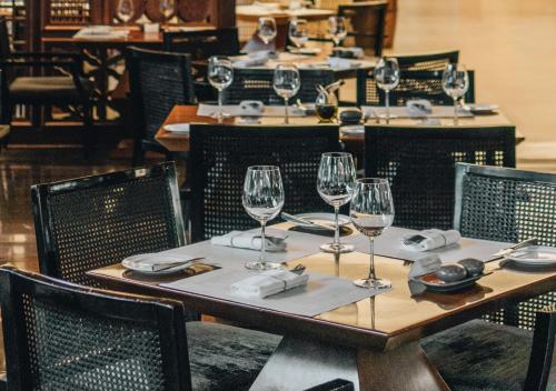 a wooden table with wine glasses and napkins on it at JW Marriott Hotel & Suites Saigon, The Apartments in Ho Chi Minh City