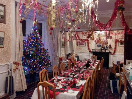 une longue table avec un sapin de Noël dans une pièce dans l'établissement Palace Hotel - Small Hotel, à Oban